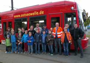 Jugendgruppe mit Begleitung vor Fahrschulwagen